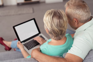 Picture of an older couple reading information on a laptop